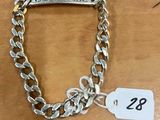 un bracelet en chaîne d'argent muni d'une plaque portant un prénom