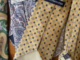 several ties are lined up on a table with a name tag