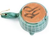 a green teapot with a brown lid on a white surface