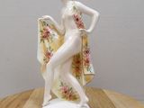 une figurine représentant une femme posée sur une table en bois