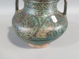 a green vase that is sitting on a table