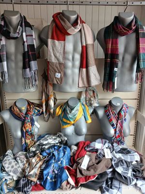 many different scarves and scarves on display in a store