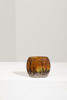 un vase en verre orange posé sur une table blanche