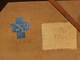 a piece of fabric with a cross on it next to a pencil