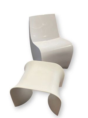 pair of white chairs and a table on a white background