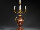 une image représentant un vase rouge et doré sur lequel sont posées trois bougies