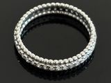 a close up of a pair of silver bracelets on a black surface