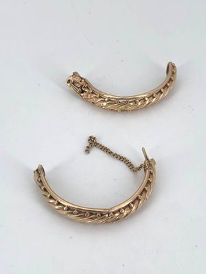 a pair of gold earrings on a white surface