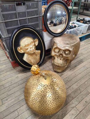 two gold skulls and a gold pumpkin on the floor