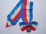 un ruban rouge, blanc et bleu et une médaille sur un fond blanc