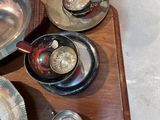 a wooden table with silver dishes and cups on it