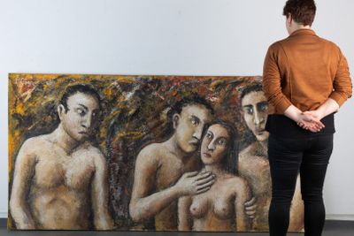 une femme debout devant un tableau représentant trois hommes nus