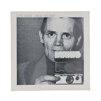 black and white photograph of a man holding a camera in front of his face