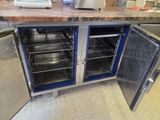 a counter with two open doors and a counter top with a laptop on top of it