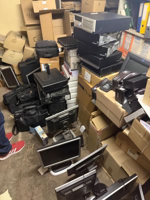 un tas d'ordinateurs et d'autres appareils électroniques dans une pièce