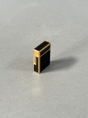 a close up of a small black and gold object on a table