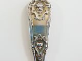 a spoon with a design on it sitting on a table