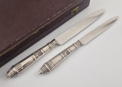 two knives and a knife holder on a table