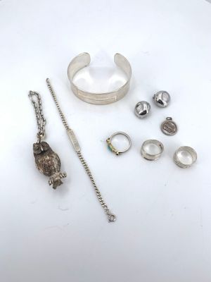 bijoux en argent posés sur un fond blanc, avec une chaîne et un bracelet