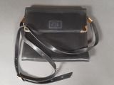 black leather purse with gold accents on a white surface