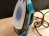a blue and black iron sitting on a wooden table