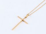 a gold cross necklace on a white background