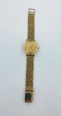 a close up of a gold watch on a white surface