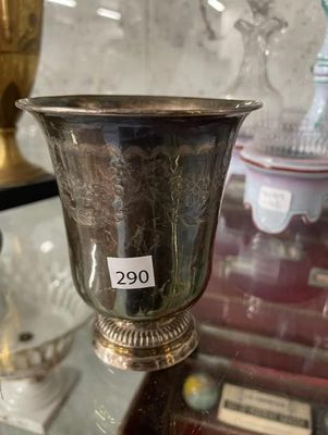 une coupe en argent posée sur une table en verre, avec une étiquette de prix dessus