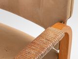 the back of a brown leather chair with a wooden arm rest