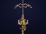 a gold plated cross on a stand with three candles