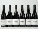 six bouteilles de vin sont alignées sur une table