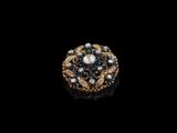 un gros plan d'une bague en or et diamants sur fond noir