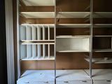 a room with a bed and shelves in it