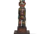 a close up of a statue of a person on a wooden base
