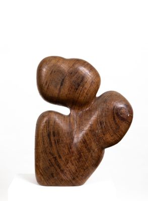 a wooden sculpture that is sitting on a white surface