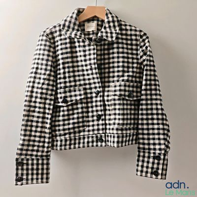 a black and white checkered jacket hanging on a hanger