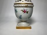 an image of a white and gold vase with flowers on it