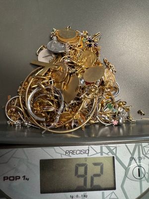 un tas de bijoux en or posé sur une balance électronique