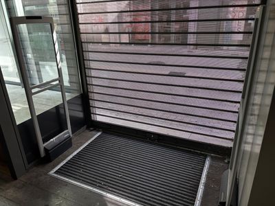 une porte noire munie d'une grille métallique