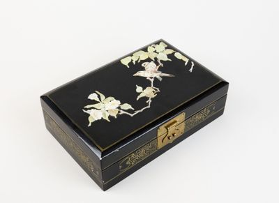 une image représentant une boîte noire et dorée ornée de fleurs