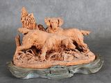 une statue représentant un chien et deux chiens sur un rocher