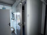 une salle de bains dotée d'une porte vitrée et d'un WC