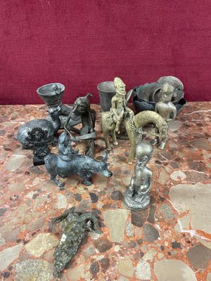 a lot of statues sitting on a table with a red wall in the background