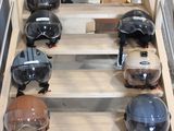 Plusieurs casques sont alignés sur une étagère en bois dans une pièce