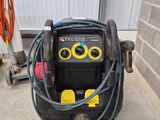 a small air compressor on the ground next to a hose