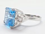 an image of a ring with a blue topaz stone surrounded by baguets of diamonds