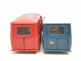 two toy trucks sitting side by side on a white surface