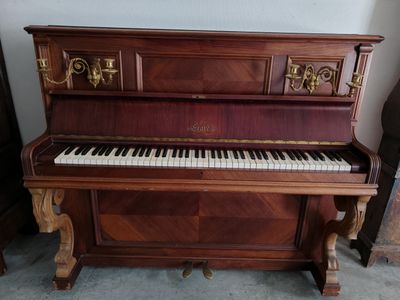 un piano qui se trouve dans le coin d'une pièce