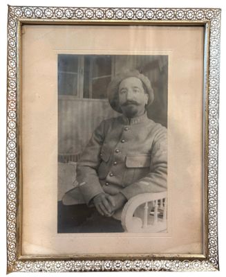 an old picture of a man in a military uniform sitting in a chair