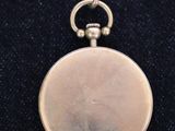 a close up of a silver pocket watch on a black cloth